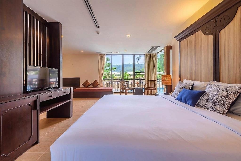 Lit d'une suite familiale de deux chambres avec vue piscine au Patong Lodge Hotel