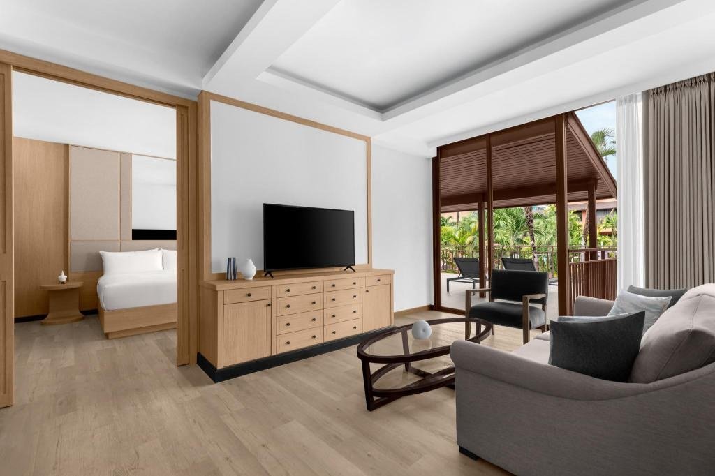 Salon séparé d'une suite familiale de deux chambres avec lit king-size, deux lits simples et canapé-lit au Courtyard by Marriott Phuket, Patong Beach Resort